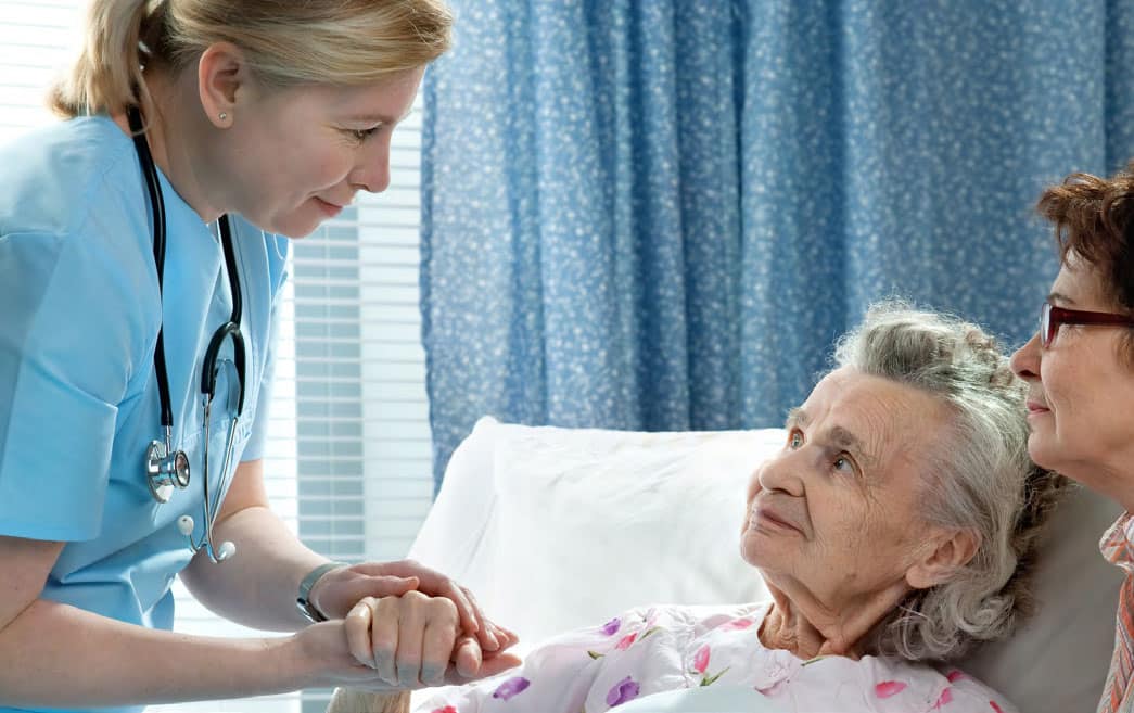 nurse holding elderly patients hand